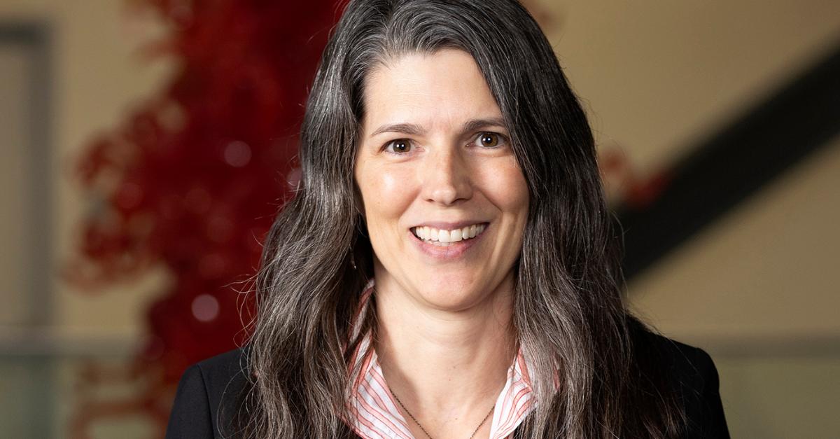 A woman with long hair wearing a red shirt.