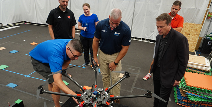 group of people looking at large drone