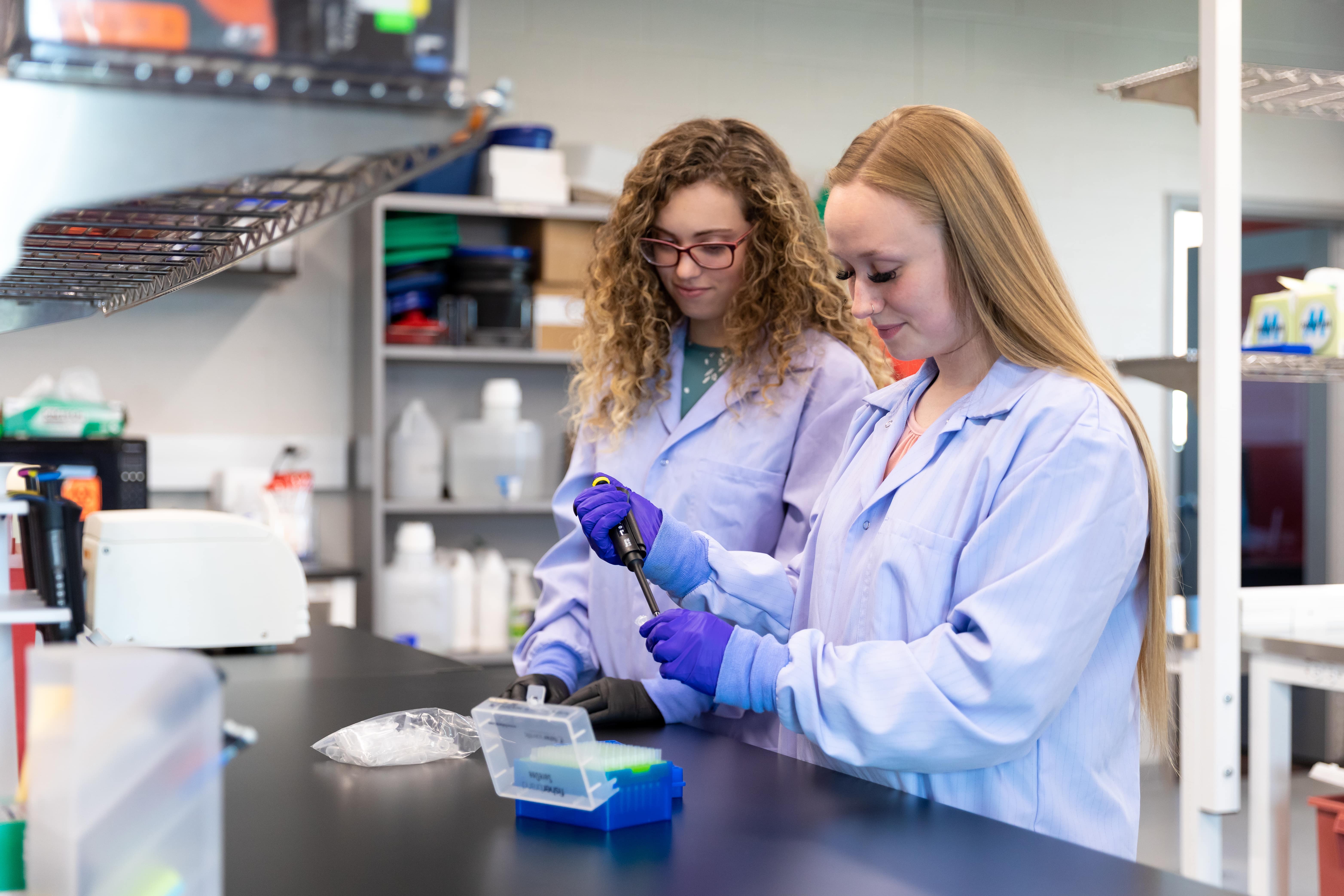 Two student researchers working in the lab