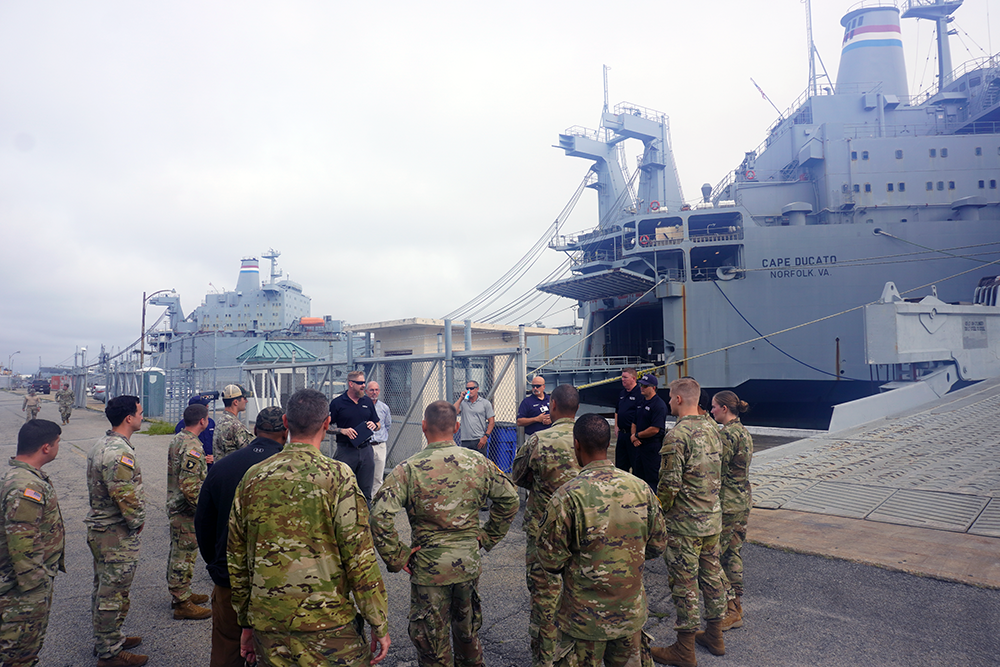 NSRI operator talking to group of course partcipants in front of naval ship
