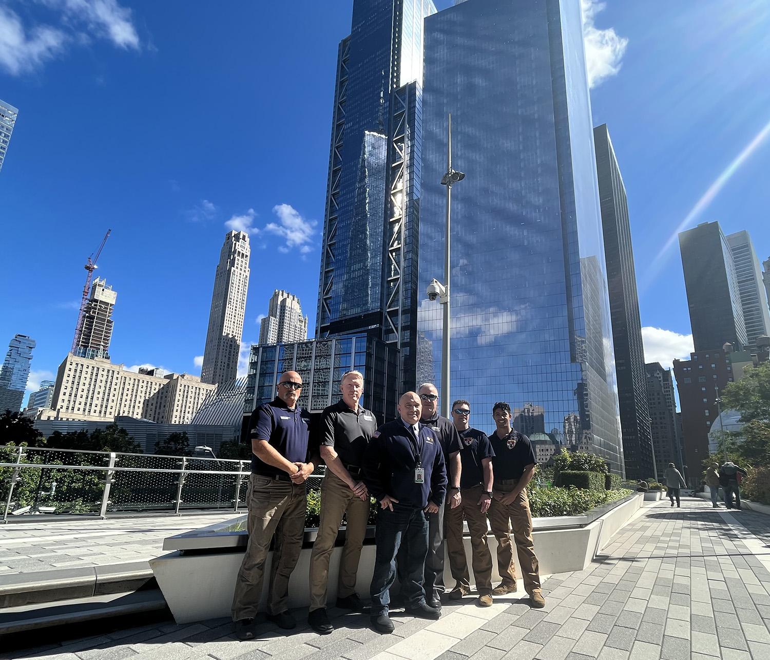 Group of men in front of One World Trade Center and the National September 11 Memorial & Museum
