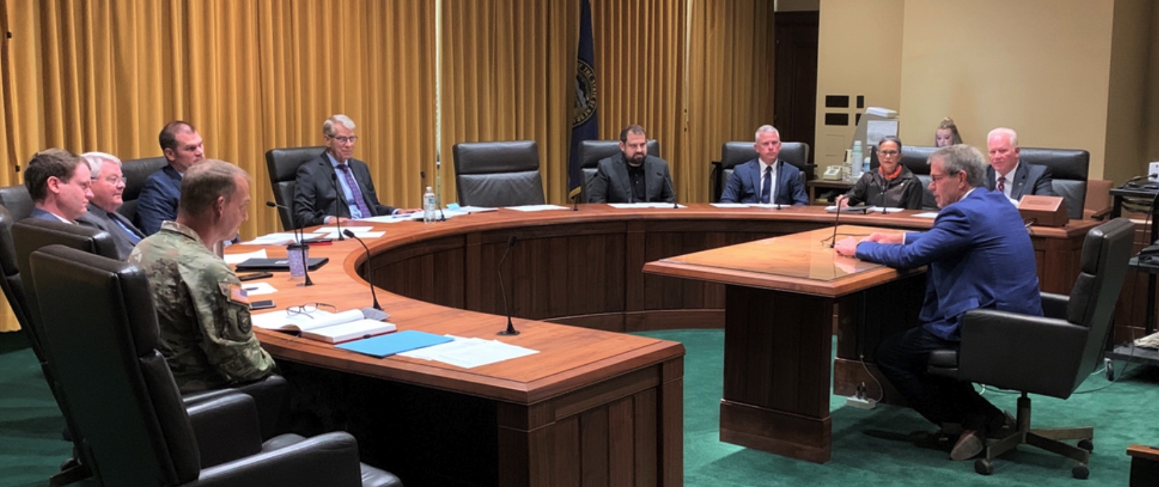 Leaders sit at table listening to Governor