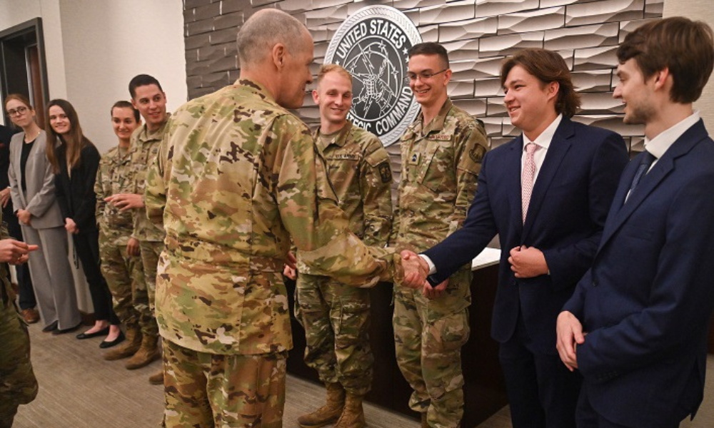 Young male student shaking hands with military leader