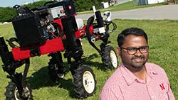 Santosh Pitla poses with the Flex-Ro autonomous tractor in June 2019.