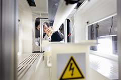 Yury Salkovskiy, Ph.D., works in the Materials Lab taking off cloth created by laying material over a cylindrical tube using an electrical field.