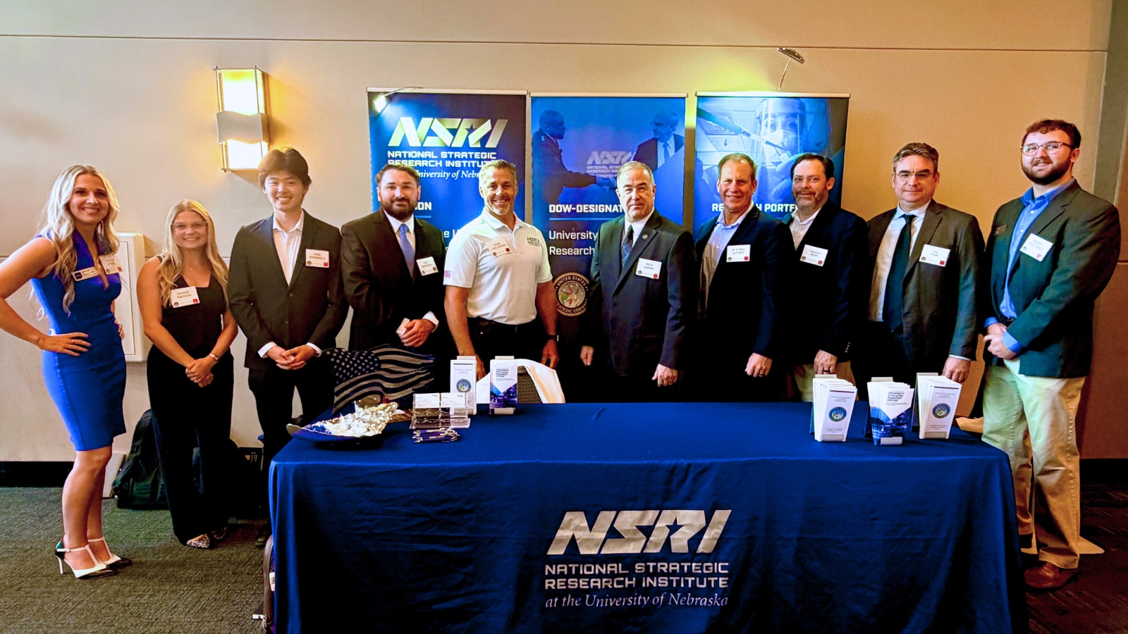 NSRI staff, researchers and students pose for a photo infront of their booth at the USSTRATCOM Strategic Deterrence Symposium
