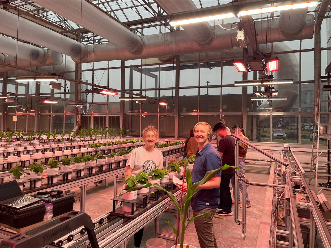 Researchers stand for a photo in a greenhouse