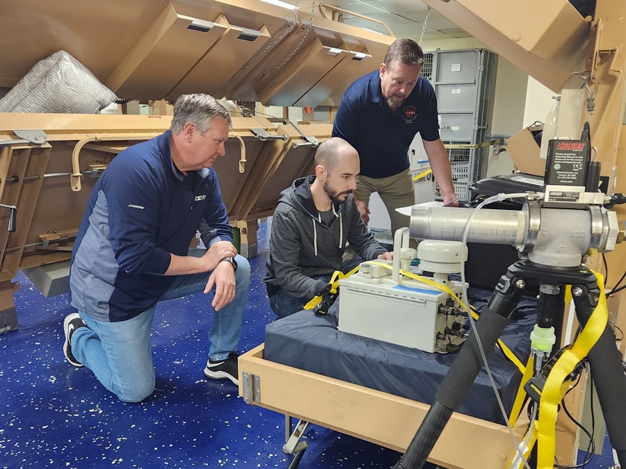 NSRI research team sets up testing equipment for particle
                            dispersal research on board USNS Mercy in February 2024